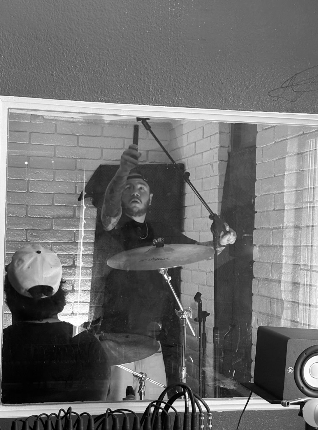 GoatHead Audio engineer positioning an overhead microphone through a studio window